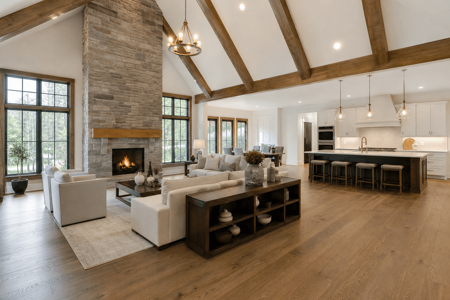 Luxury custom home great room with vaulted wood-beam ceiling, stone fireplace, and open kitchen