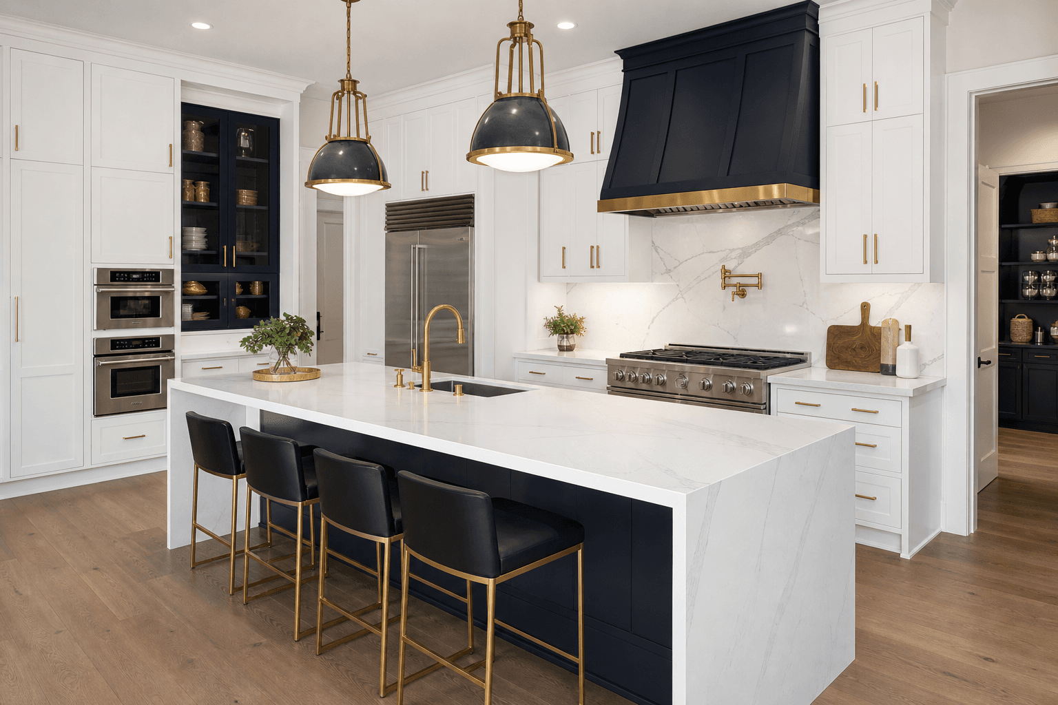 Gourmet custom kitchen with waterfall quartz island, navy cabinetry, and brass fixtures